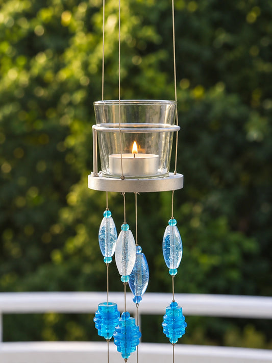Blue Glass Beaded Hanging Votive – ILLUMEA handcrafted decorative candle holder featuring a clear glass votive, silver metal frame and cascading strands of blue and turquoise glass beads