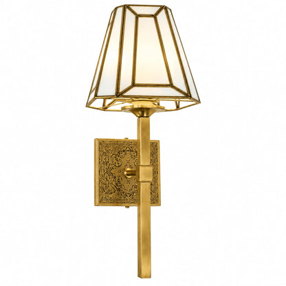 Antique Brass Geometric Wall Sconce by ILLUMEA with a decorative engraved backplate, long vertical arm, and contemporary faceted glass shade