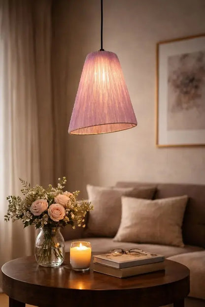 Cozy living room with a pink pendant lamp, flowers, and a candle on a table.