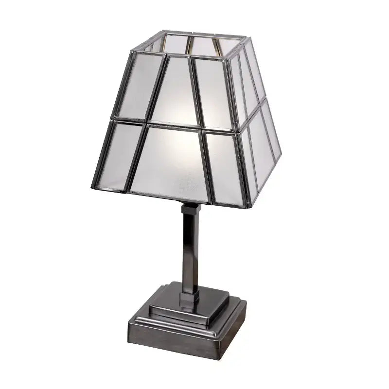 Table lamp with geometric glass shade on a white background