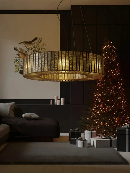 Decorative lamp hanging above a bed in a room with a Christmas tree and presents.